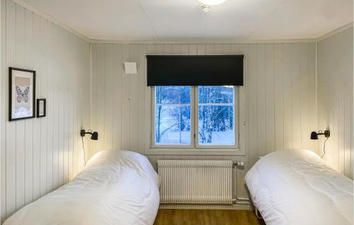 2 camas en una habitación con ventana en Stunning Apartment In Mesnali With House A Panoramic View, en Mesnali