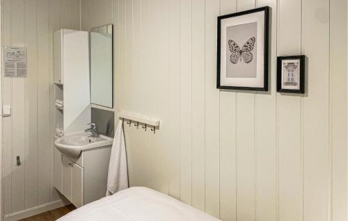 La salle de bains est pourvue d'un lavabo, de toilettes et d'un miroir. dans l'établissement Nice Apartment In Mesnali With Internet And 1 Bedrooms, à Mesnali