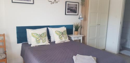 a bedroom with a bed with butterfly pillows on it at NORTH in Jastrzębia Góra