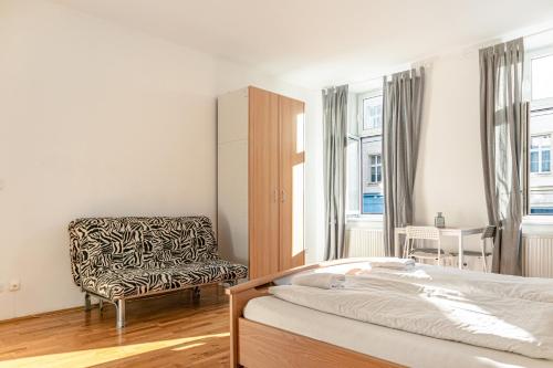 a bedroom with a bed and a chair at Comfortable 3BR shared Apart. - Suitable For Long Stays in Vienna