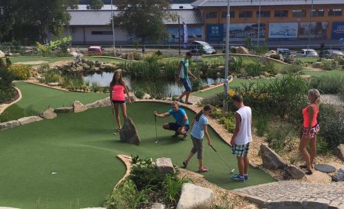 a group of people playing golf on a miniature golf course at Apartmány Pinie Lipno in Lipno nad Vltavou