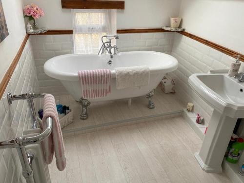 a bathroom with a white tub and a sink at Seaview Cottage in Bridlington