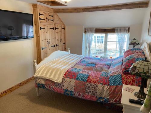 a bedroom with a bed with a quilt on it at Seaview Cottage in Bridlington