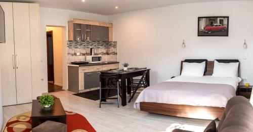 a bedroom with a bed and a desk and a kitchen at Aparthotel Metropol in Iaşi