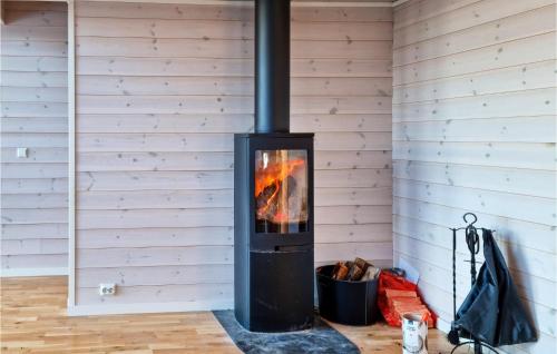 a wood stove in a room with a wall at Stunning Home In Lyngdal With Wifi in Lyngdal