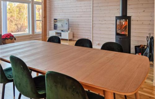a wooden table and chairs in a room with a fireplace at Stunning Home In Lyngdal With Wifi in Lyngdal