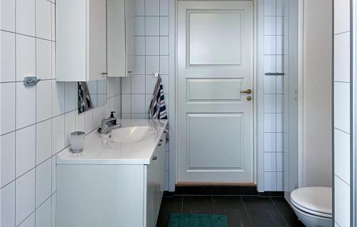 Baño blanco con lavabo y aseo en Cozy Home In Valsyfjord With House Sea View en Valsøyfjord
