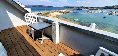 a balcony with a chair and a view of a harbor at Le Thalassa Hôtel & Spa in Camaret-sur-Mer