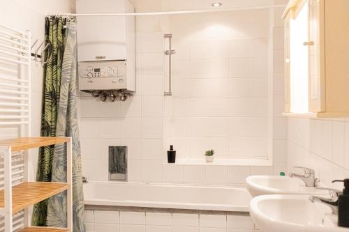 a white bathroom with a tub and a sink at Comfortable 3BR shared Apart. - Suitable For Long Stays in Vienna