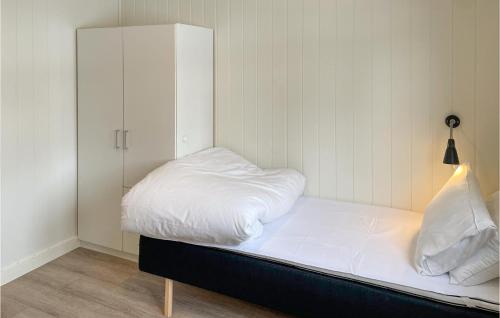 uma cama com lençóis brancos e um armário branco em Gorgeous Apartment In Mesnali With Kitchen em Mesnali