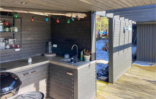 an outdoor kitchen with a sink and a patio at Stunning Home In Mosterhamn With Kitchen in Mosterhamn