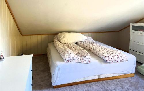 a bed with two pillows on it in a room at Stunning Home In Mosterhamn With Kitchen in Mosterhamn