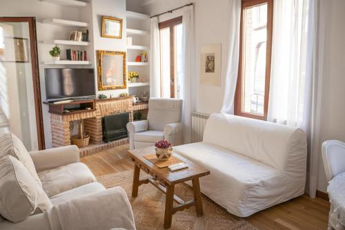 a living room with two white couches and a tv at Hammam de Zeid in Toledo