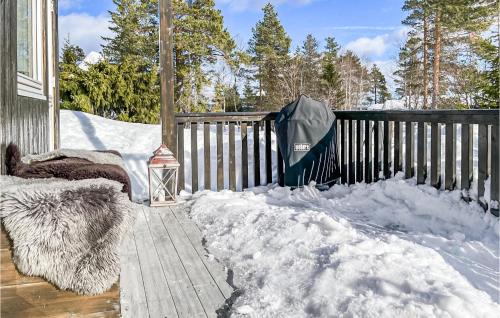 a porch covered in snow next to a fence at Beautiful Home In Noresund With Wifi in Noresund