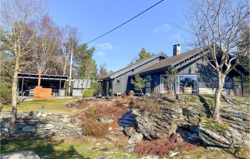 a home with a stone yard and a building at Amazing Home In Mosterhamn in Mosterhamn