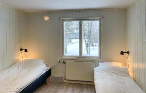Duas camas num quarto com uma janela em Pet Friendly Apartment In Mesnali With Kitchen em Mesnali
