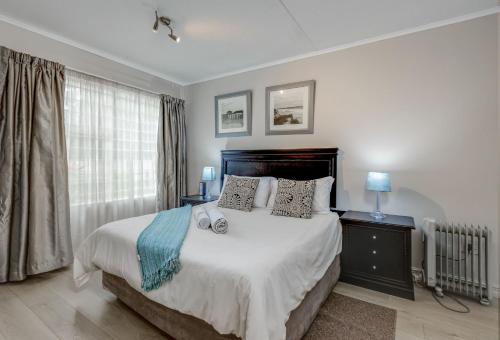 a bedroom with a large bed and a window at RAD STAYS - 26 Madison Palms East 112 North Road Sandown in Johannesburg