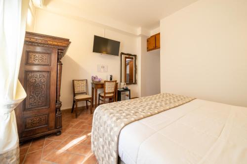 a bedroom with a bed and a table with chairs at Affittacamere Valentina in Orvieto