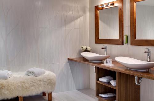 a bathroom with two sinks and a mirror at LA CHENEAUDIÈRE - Hôtel Spa - Relais & Châteaux - Restaurant étoilé in Colroy-la-Roche