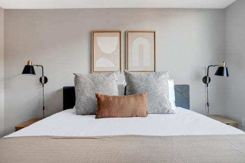 a bedroom with a white bed with two lamps at Clarendon 1BR w Gym WD Pool nr Metro WDC-381 in Arlington