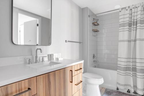 a bathroom with a sink and a toilet and a tub at Clarendon 1BR w Gym WD Pool nr Metro WDC-381 in Arlington