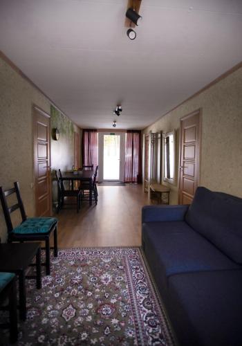 a living room with a blue couch and a table at Kempings Ozolkalns in Cēsis