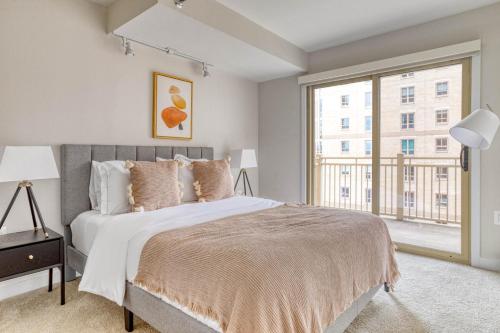 ein Schlafzimmer mit einem großen Bett und einem großen Fenster in der Unterkunft Ballston 2BR w Concierge WD Pool nr Metro WDC-505 in Arlington