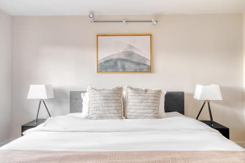 a bedroom with a large white bed with two lamps at Clarendon 1BR WD Concierge Gym nr WF WDC-518 in Arlington