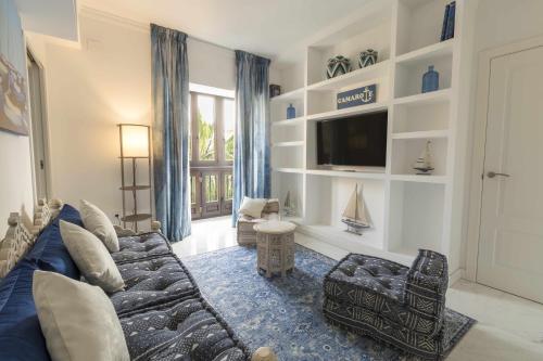 a living room with a couch and a tv at THE CLOCK HOUSE Luxury Urban Suites in Málaga