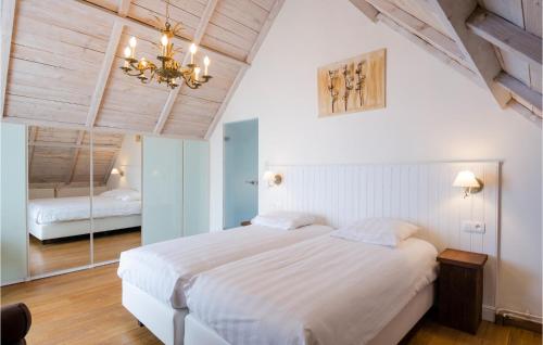 威斯圖特的住宿－Cozy Home In Westouter With House A Panoramic View，卧室配有一张白色大床和吊灯。