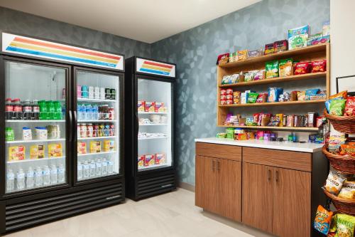 a store aisle with two refrigerators and food at Holiday Inn Express and Suites Wheeling by IHG in Triadelphia