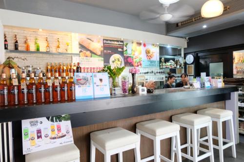 un bar con taburetes blancos en un restaurante en Baanpoon Apartment, en Chaweng