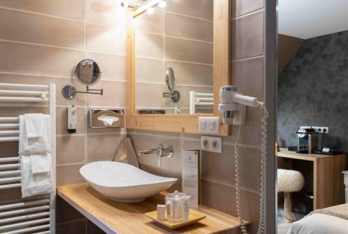a bathroom with a sink and a mirror at LA CHENEAUDIÈRE - Hôtel Spa - Relais & Châteaux - Restaurant étoilé in Colroy-la-Roche