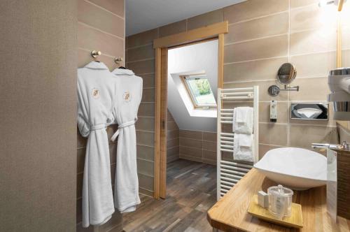 a bathroom with white towels hanging on a wall at LA CHENEAUDIÈRE - Hôtel Spa - Relais & Châteaux - Restaurant étoilé in Colroy-la-Roche