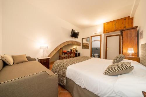 a bedroom with two beds and a couch at Affittacamere Valentina in Orvieto