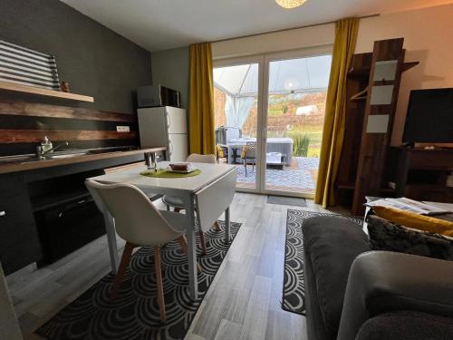 une cuisine et un salon avec une table et des chaises dans l'établissement Lodge spa privatif Silex, séjour zen, à Meisenthal