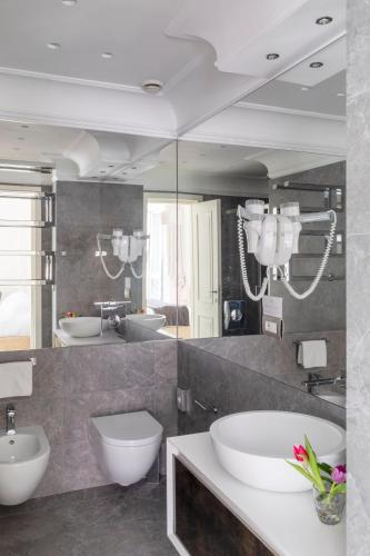 a bathroom with two sinks and two mirrors at Hotel Scalinata Di Spagna in Rome