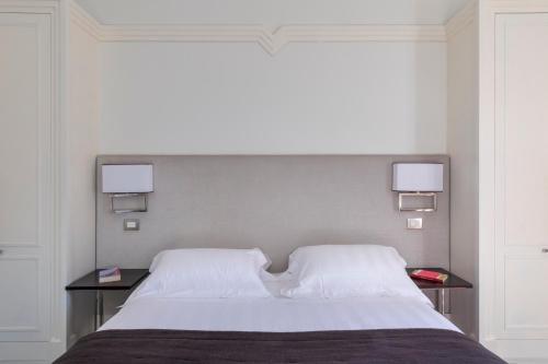 a bedroom with a large bed with two night stands at Hotel Scalinata Di Spagna in Rome