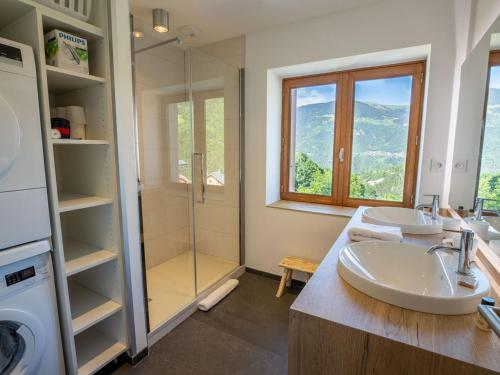 une salle de bain avec deux lavabos et une douche en verre dans l'établissement Chalet rénové à Méribel · Cheminée · 4 chambres · Calme · Parking - FR-1-688-17, à Méribel
