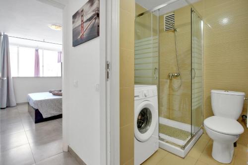 een badkamer met toilet en wasmachine bij Chasna in Costa Del Silencio