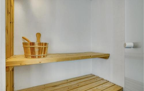 a wooden shelf with a basket and two wooden spoons at Holiday Home Strandgården in Sæby