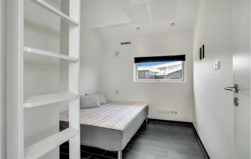 um pequeno quarto com uma cama e uma janela em Cozy Home In Sby With House Sea View em Sæby