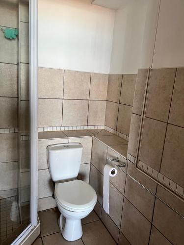 a bathroom with a toilet and a roll of toilet paper at L’Escalier Cabanas 510 in Amanzimtoti