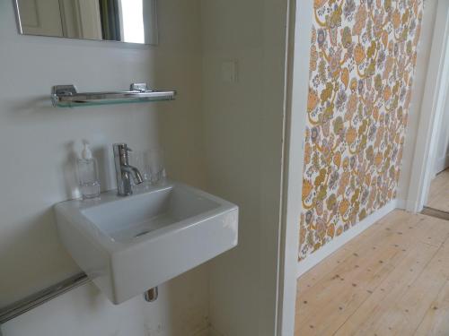 een badkamer met een witte wastafel en een spiegel bij Bickersbed in Amsterdam