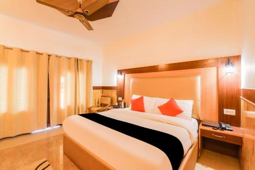 sypialnia z dużym łóżkiem z pomarańczowymi poduszkami w obiekcie Collection O Signature Manaali w mieście Baragrān