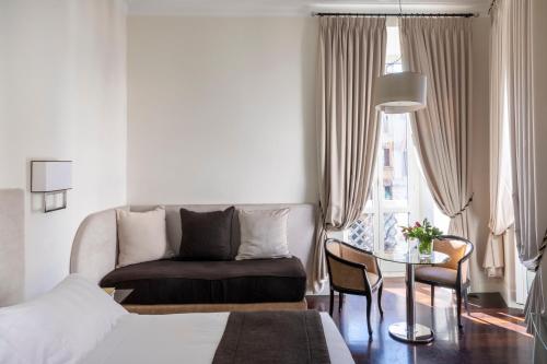 a hotel room with a bed and a table and a couch at Hotel Scalinata Di Spagna in Rome