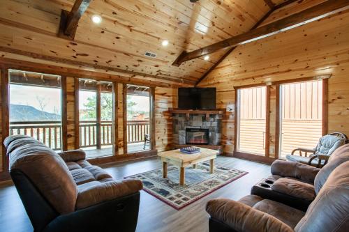a living room with couches and a fireplace in a log cabin at Pool and Game Room in Stunning Mountain Cabin in Pigeon Forge