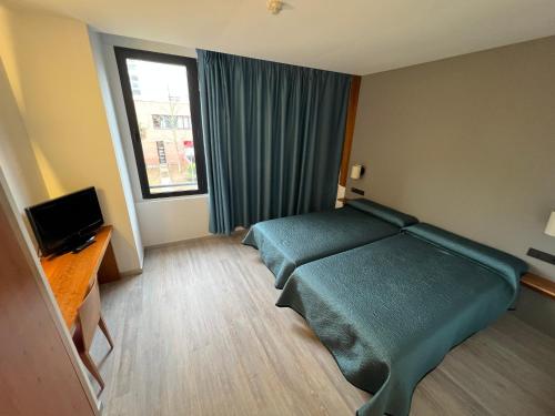 a hotel room with a bed and a window at Duque de Wellington in Vitoria-Gasteiz
