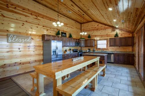 a large kitchen with wooden walls and a wooden table at Pool and Game Room in Stunning Mountain Cabin in Pigeon Forge