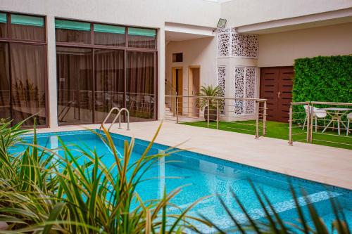 a villa with a swimming pool and a house at Hôtel les Vallons in Abidjan